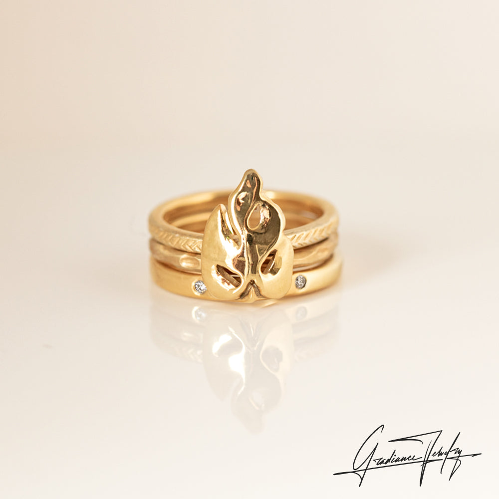 Gradiance Jewelry women's 14KT Yellow Gold Growth Ring featuring a mini monstera leaf and two small lab-created diamonds on the band - shown with 14KT yellow gold textured stacker rings set neatly behind the leaf.