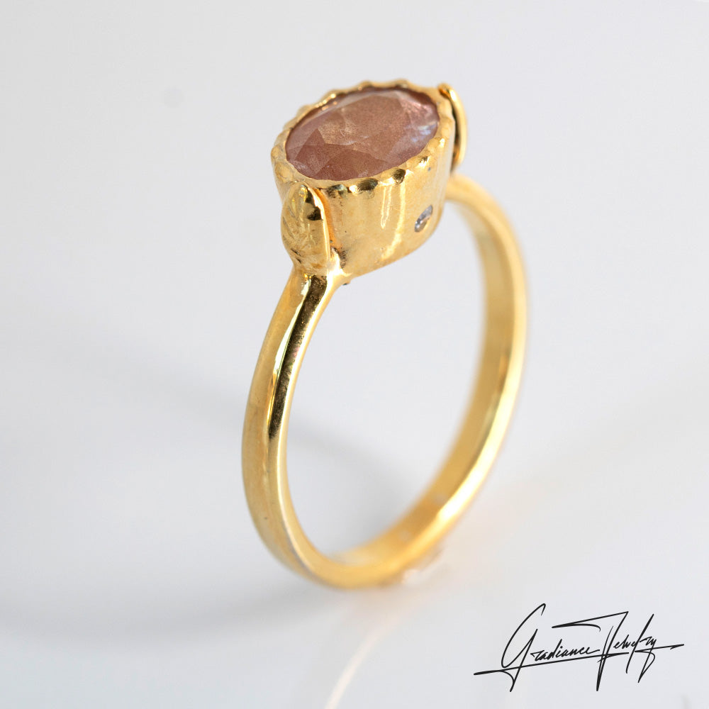 Gradiance Jewelry Sun Chaser Collection: women's 14KT yellow gold Rose ring featuring an oval Oregon Sunstone with schiller effect, accented by two diamonds and a leaf design, leaf  view.