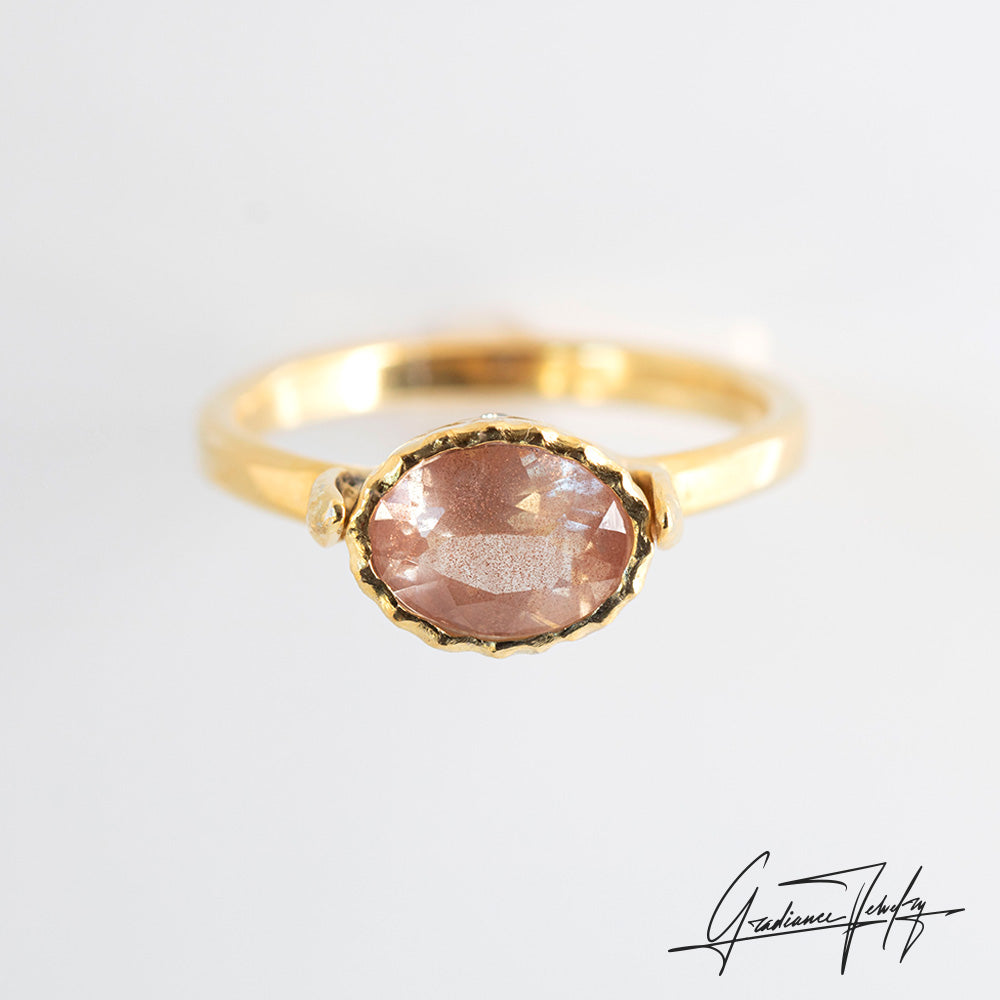 Gradiance Jewelry Sun Chaser Collection: women's 14KT yellow gold Rose ring featuring an oval Oregon Sunstone with schiller effect, accented by two diamonds and a leaf design, product shot.